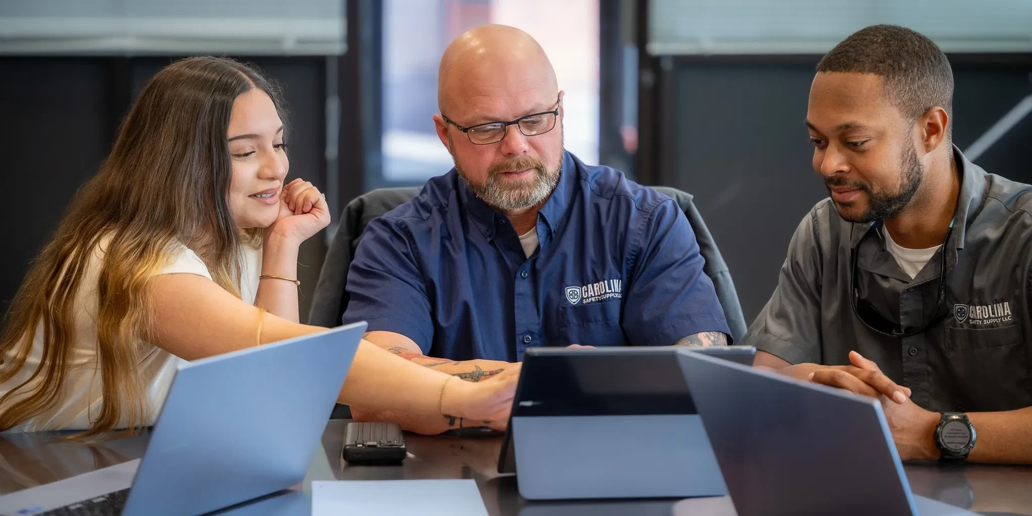 Team members collaborating around laptops